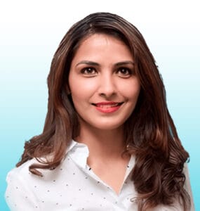 Meet the team: Woman with long brown hair wearing a white button-up shirt, smiling, posed against a light blue gradient background.