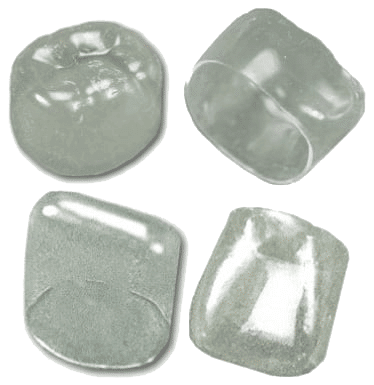Four clear dental crowns are arranged on a plain background, each showing different angles and shapes of the crowns.